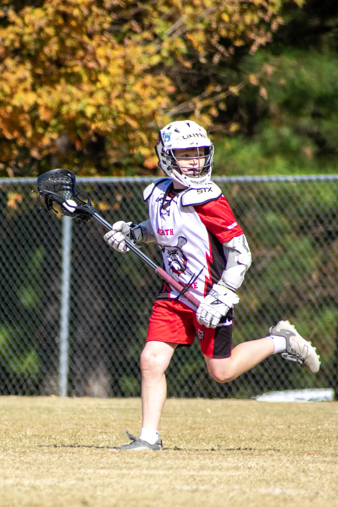 North Gwinnett middle school lacrosse player running with stick