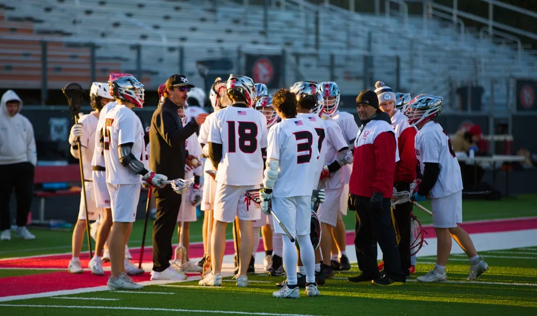 North Gwinnett boys lacrosse team huddle with coaches