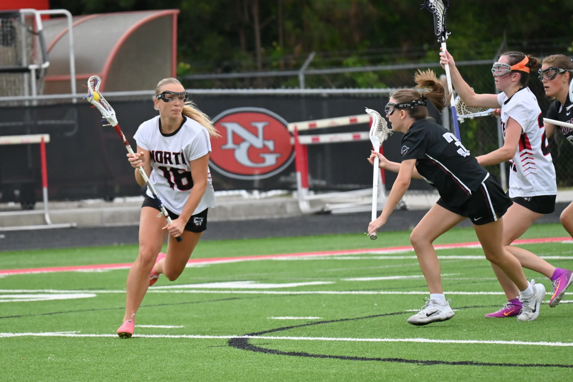 Girls lacrosse players competing during a game